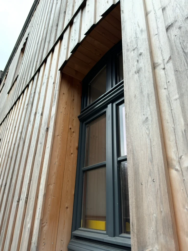 Rundbogenfenster in Holzschalung