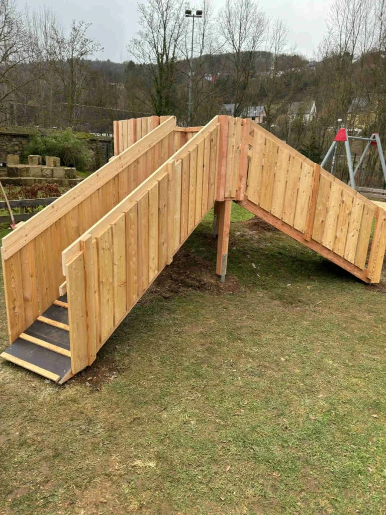 Kinderspielturm aus Lärchenholz mit zwei Aufgängen und einer Rutsche.