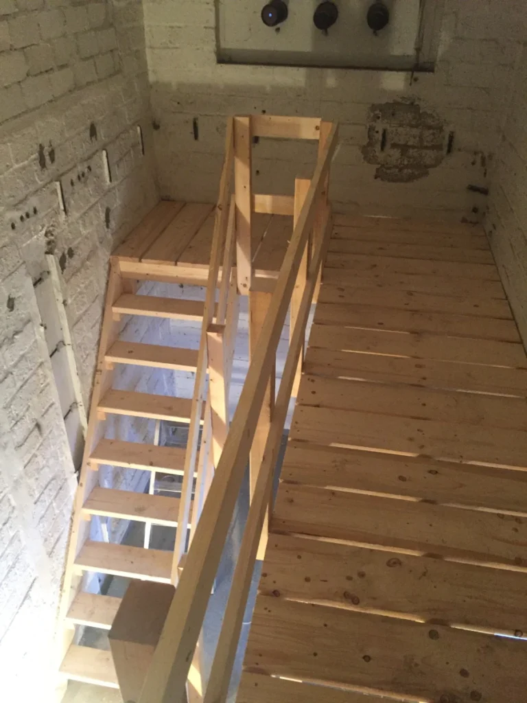 Innenraum eines Treppenaufgangs und ein Holzsteg in einem Vogelschutzturm des NABUs