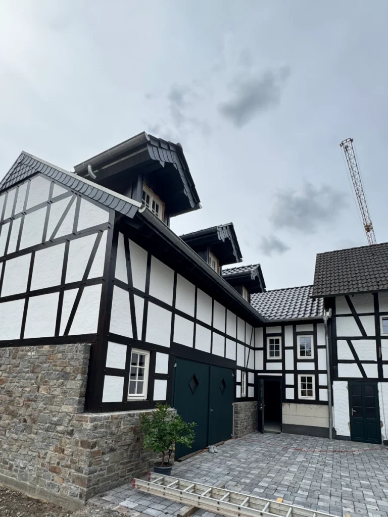 Neubau eines fertigen Fachwerkhaus. Holzbalken in schwarz gestrichen und gefache in Weiß verputzt.