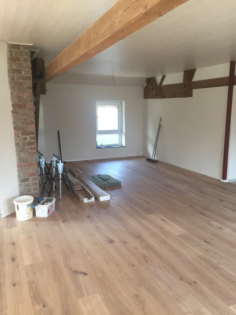 Eichenparkettboden in Kombination mit weißen Deckenpaneelen aus Holz.